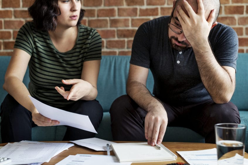 A couple looking at documents to try to manage their debt.