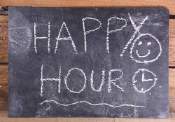 Happy hour text on a blackboard.