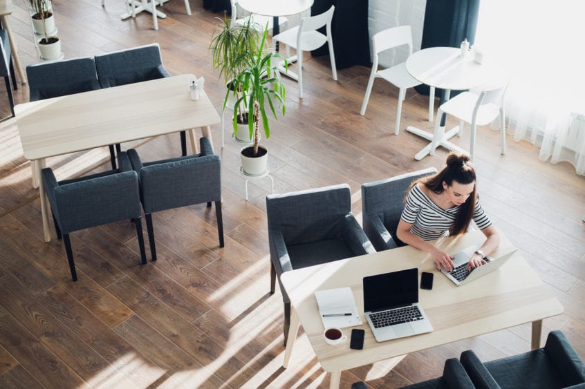 A woman on a laptop working in a modern office space.